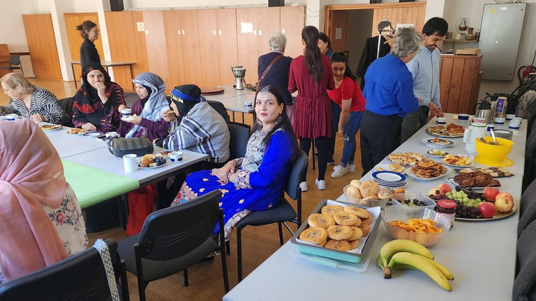 Buffet uns Frauen, die an Tischen sitzen und essen und trinken