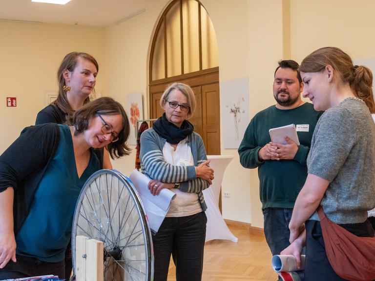 Manchmal gewinnt das Glück: Carolin Wildt (links) von der Immanuel Beratung Fischerinsel erklärt die Zufallswege von Neuzugewanderten - Interessierte beim Workshop „Aktionstag der Migrationsberatung für erwachsene Zugewanderte“