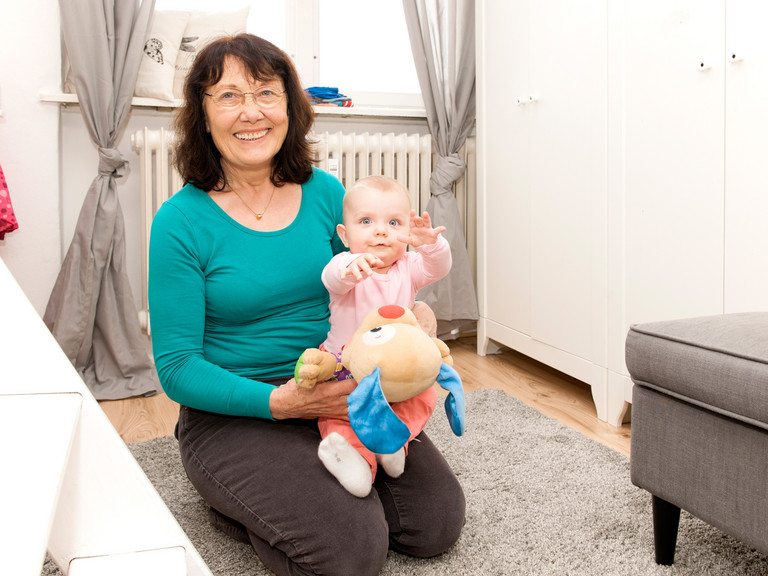 Ehrenamtliche mit Baby auf Schoß