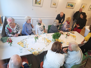 Senatorin und Gäste tauschen sich an einem Kaffeetisch angeregt aus - Immanuel Stadtteilzentrum Borsigwalde