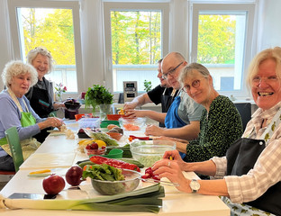 Gäste schneiden Gemüse an einem Tisch